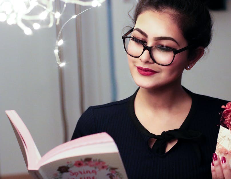 Girl with glasses reading a book
